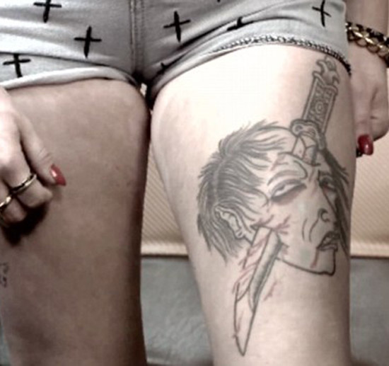 Knife through skull tattoo on thigh